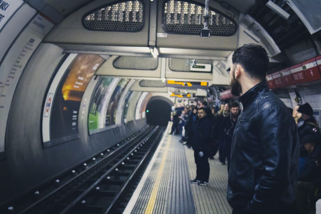 A large group of business commuters waiting for a train in an underground station
