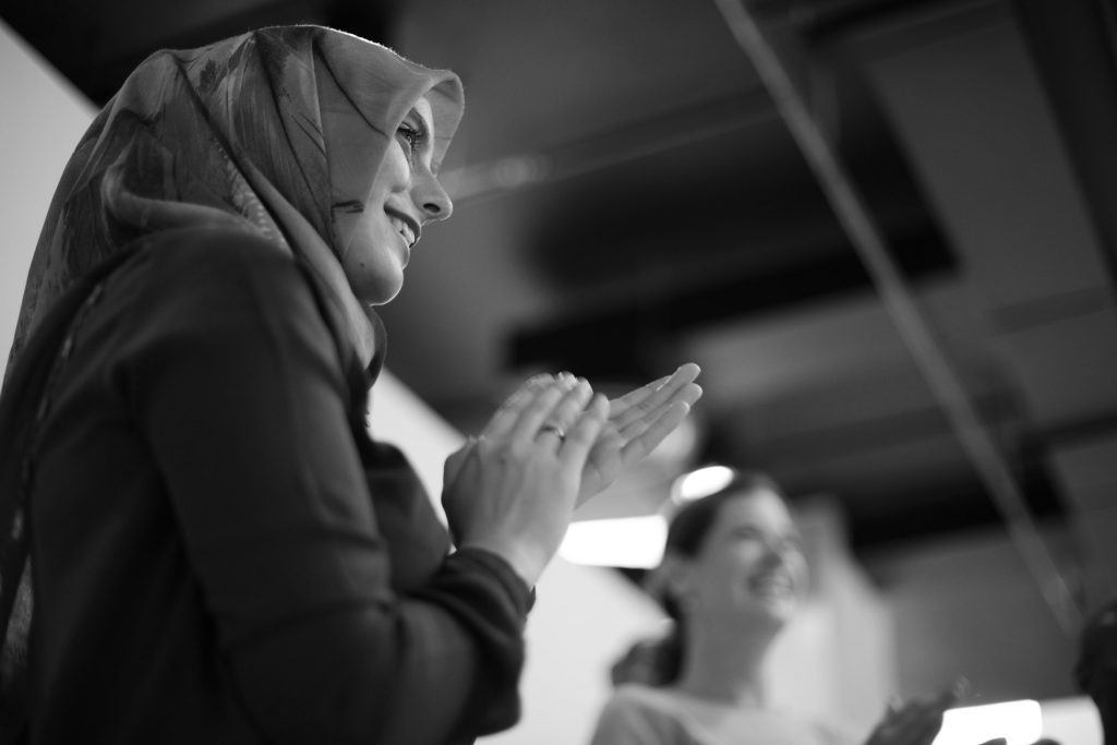 A black and white photo of a women clapping.