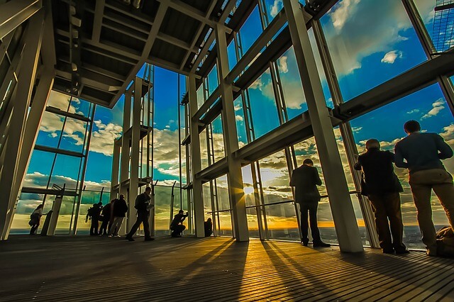 People in building with glass walls at sunset