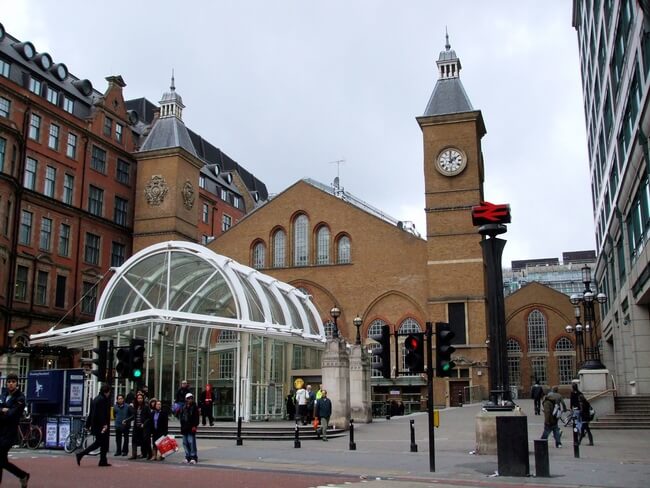 train station entrance, glass front with clock tower in background